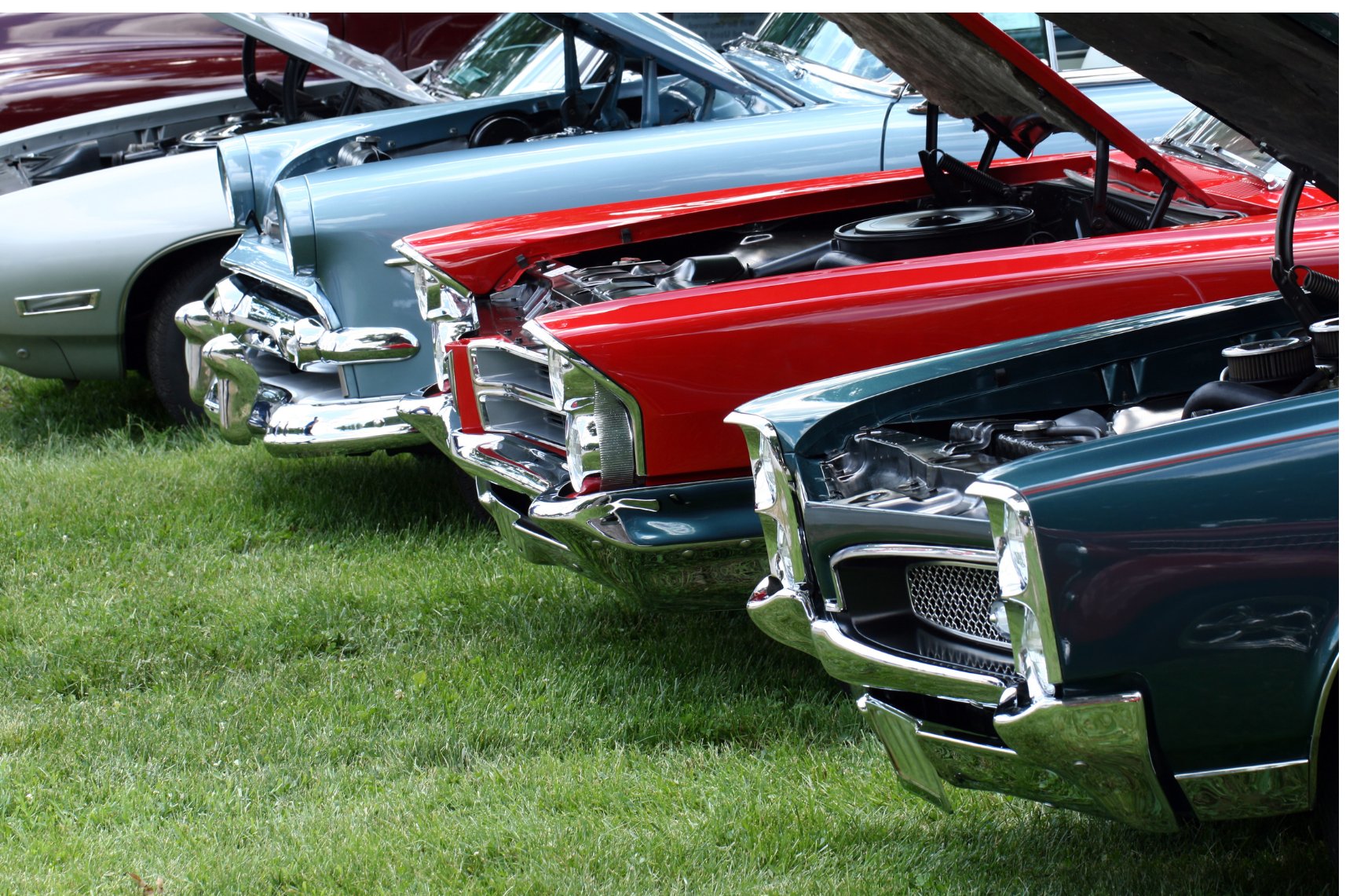 Classic American cars displayed together at an outdoor car show